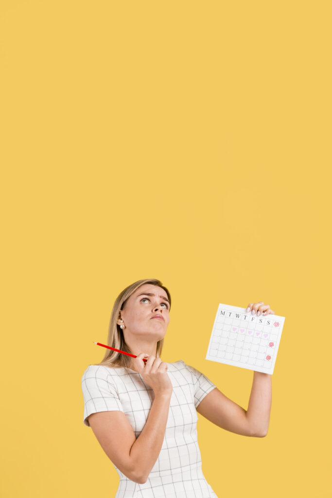 Persona penando mientras sostiene un calendario.